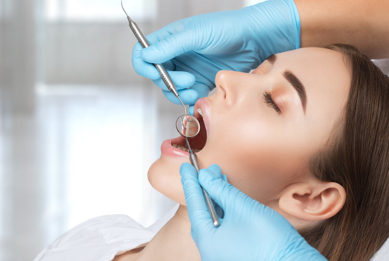 A dentist doctor treats caries on a tooth of a young beautiful woman in a dental clinic. Tooth filling. Professional Teeth Whitening in Summerville SC